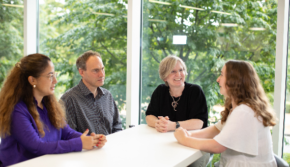 group of people smiling around a table in AtkinsRealis office